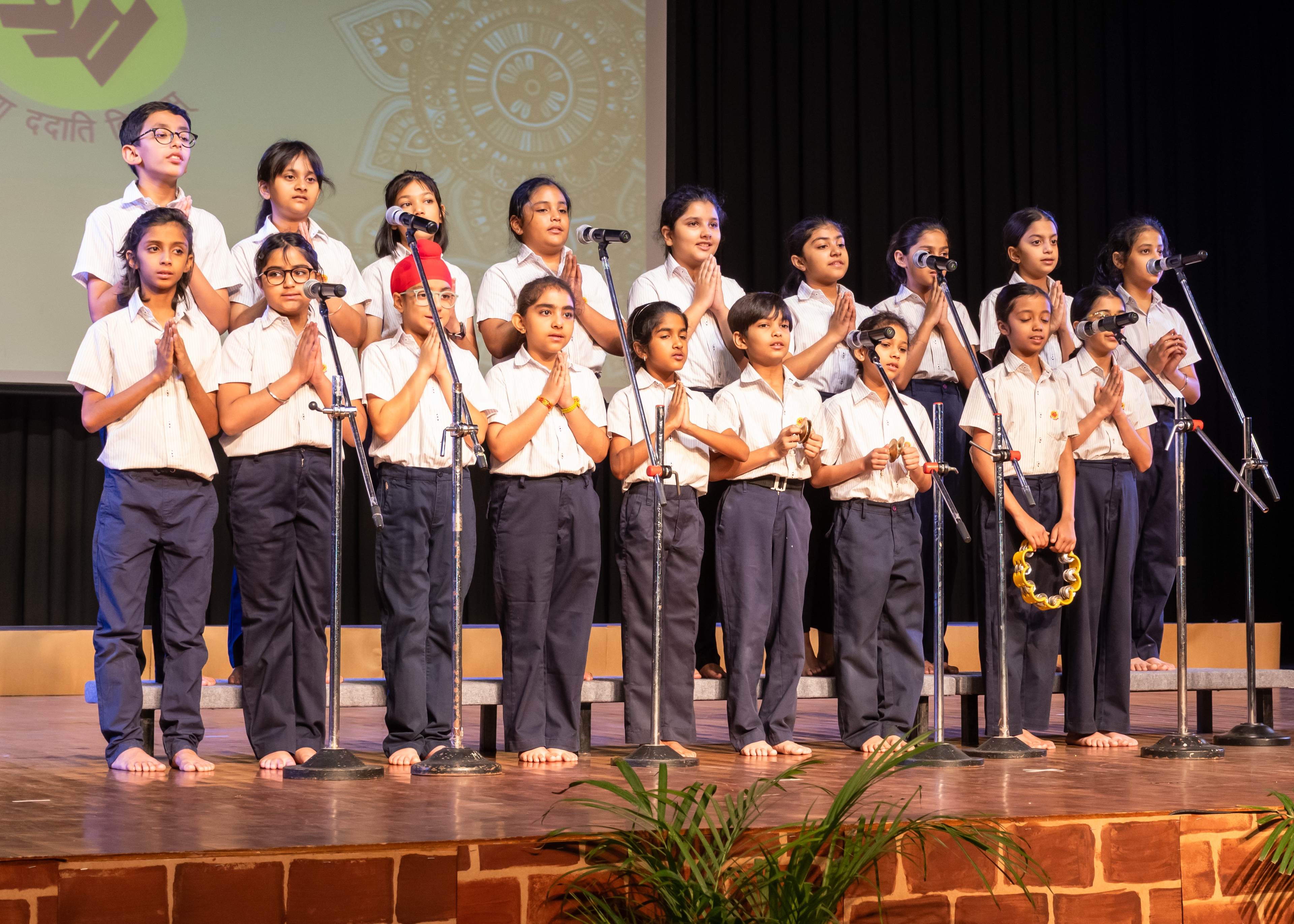 Primary students in navy sweaters listening attentively in a classroom